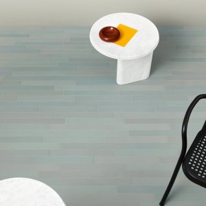 Area break con pavimento Mutina Mews color Green e tavoli in legno chiaro