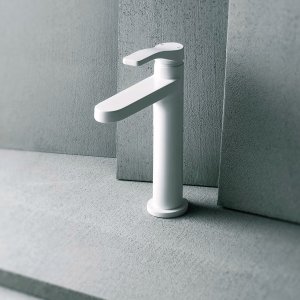 Miscelatore lavabo monoforo AL/23 di Fantini in cromo davanti a una lastra di cemento grigio