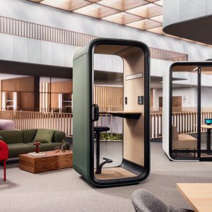 Framery One Compact inserito tra le scrivanie di un ufficio moderno
