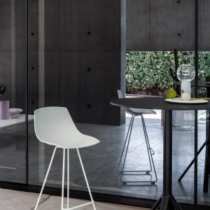 Sedia Miunn con base a slitta accanto a un tavolo