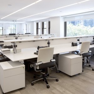Workstation condivisa Nomos con schermi intermedi e mensole attrezzate