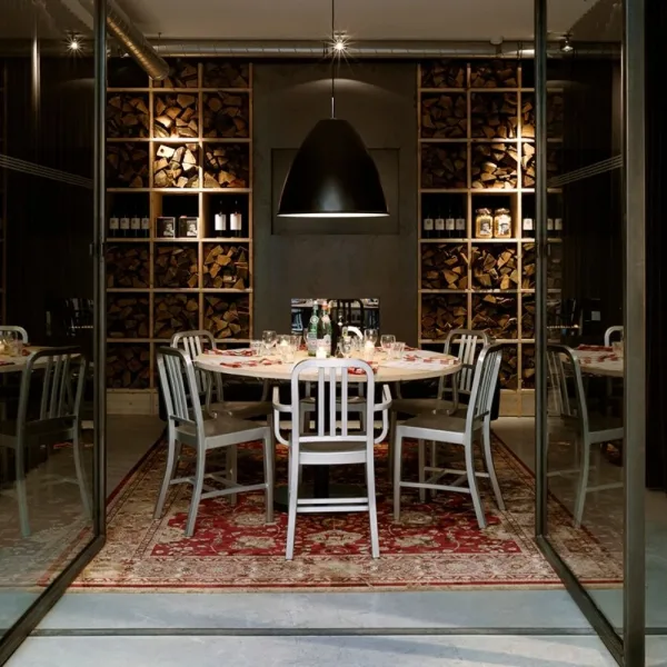 Sedute Emeco in alluminio riciclato intorno a un tavolo in una sala ristorante
