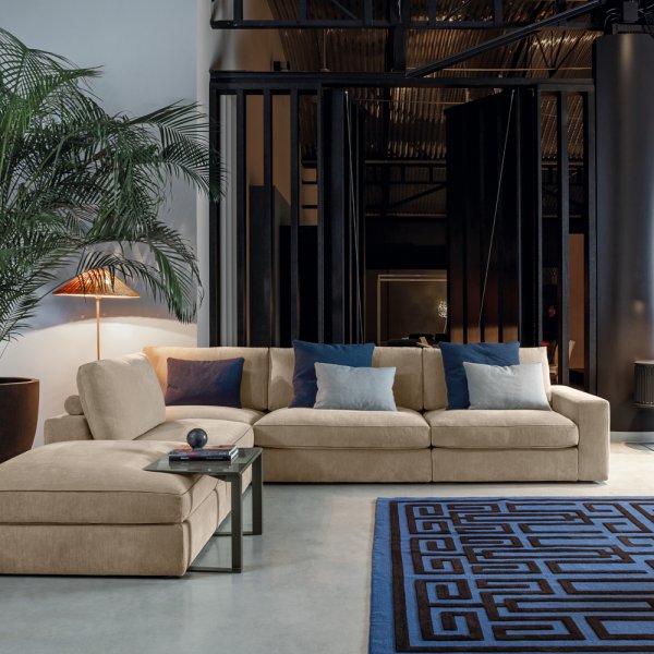 Divano Flexteam Qubik con braccioli a staffe visibili in un'area lounge